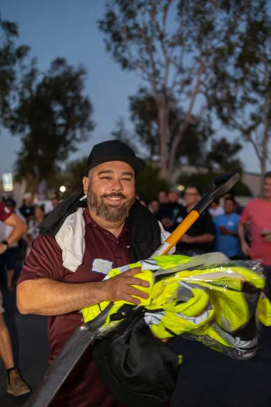 A raffle winner grinning and holding up a hi-vis safety bundle.